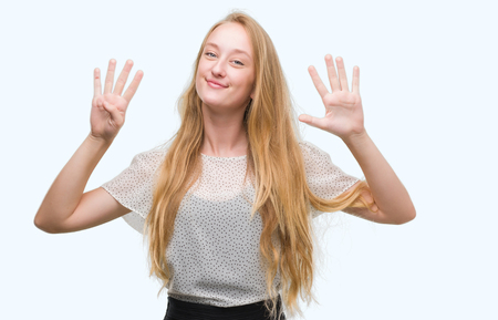 Blonde teenager woman wearing moles shirt showing and pointing up with fingers number nine while smiling confident and happy.の写真素材