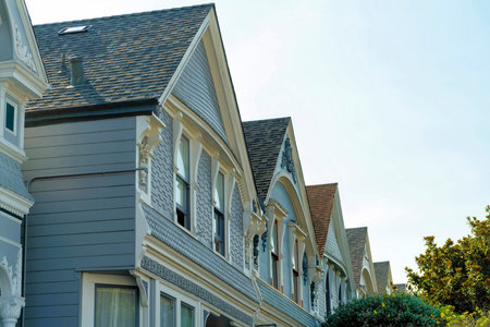 Red front door of home with glass pannel and white frame with beige paint on front porch with sign on top and red steps in foreground. In shade in afternoon in the neighborhood or on a house patio.の写真素材