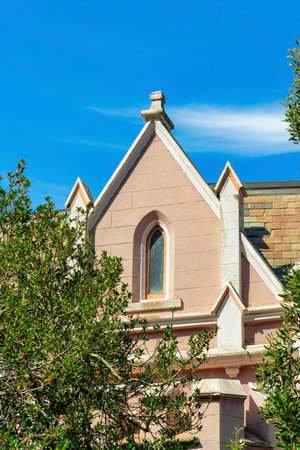 Modern home exterior or facade with victorian accents and decorations and tall chimney with blue and white gradient sky in the front yard. In the city or neighborhood in suburban area.の写真素材