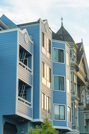 House or building facade in late afternoon sun with cream beige stucco color and rustic decorative balconies with red roof. In the neighborhood or in the downtown suburban area in the city.の写真素材