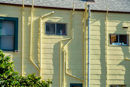 House or building facade in late afternoon sun with cream beige stucco color and rustic decorative balconies with red roof. In the neighborhood or in the downtown suburban area in the city.の写真素材