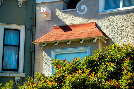 Close view of gray metal chimney pipes in sunset or twilight sun on side of building with wooden...