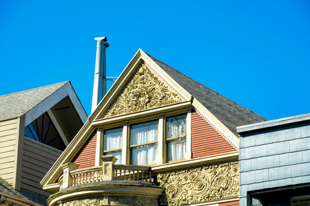 Close view of gray metal chimney pipes in sunset or twilight sun on side of building with wooden facade and blue sky background. In the city or in an urban area of the town downtown.の写真素材