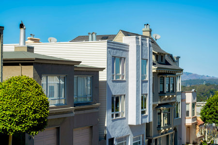 Brown wooden slatted building with metal fire escape ladder and balcony in city with flat roof and decorative facade in midday sun. In the urban part of the city apartments or town homes.の写真素材
