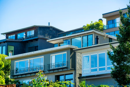 Blue door entryway with gold metal mail slot door handle with gray wooden exterior near front yard and porch or patio in shade. In neighborhood or in the downtown city with a residential entrance.の写真素材