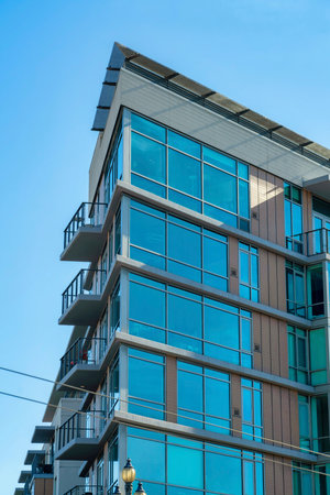 Row of modern house facades beige and green in late afternoon shade and blue and white gradient sky background. In the downtown neighborhood in historic districts of San Francisco California.の写真素材