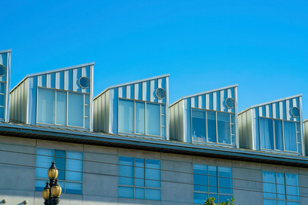 Row of modern house facades beige and green in late afternoon shade and blue and white gradient sky background. In the downtown neighborhood in historic districts of San Francisco California.の写真素材