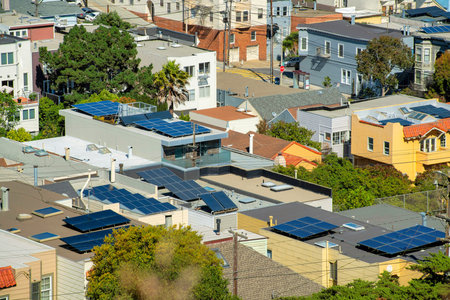 Row of modern houses in foreground with different colors and downtown city of san francisco california with skyscrappers. In afternoon sun with front yard trees and buildings in historic districts.の写真素材