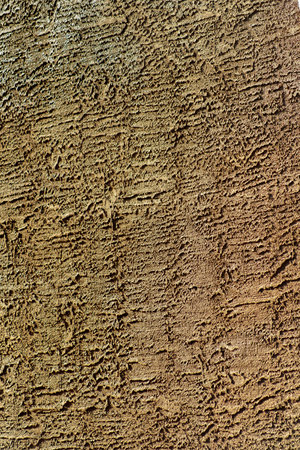 Dark stucco exterior on side of building or in industrial area with cement or concreate facade as a texture. For design purposes in late afternoon sunlight with orange or beige color.の写真素材