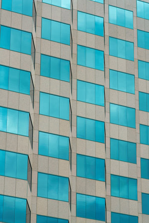 Basic business building with blue visible windows and gray facade in downtown city streets in the urban part of neighborhood. In modern districts of american town for business or office parks in silicon valley.の写真素材