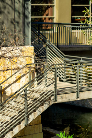 Pedestrian stairs and walkway on side of building or in commercial office area of city in afternoon sun with hand railの写真素材