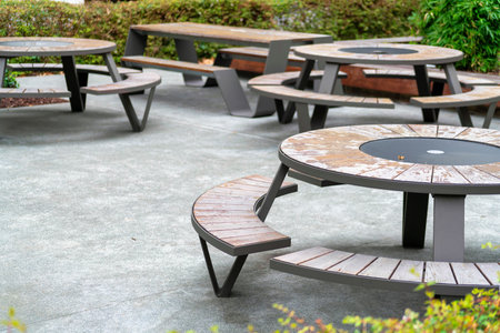 Patio or dining area porch with round lunch tables in afternoon shade in courtyard with plants and shrubs in city. Near restaurant or business for people to dine and rest in outside afternoon shade.の写真素材