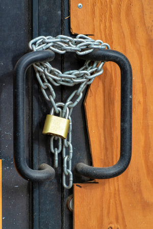 Lock and chain on downtown business boarded up with on front door entrance for bankrupcy and...
