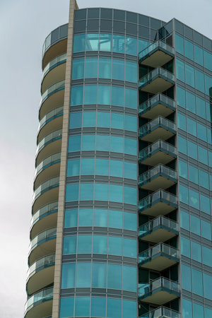 Round decorative office building or business in downtown american city in san jose california with reflective sleek glass. Late afternoon shade with clouds in commercial real estate districts.の写真素材