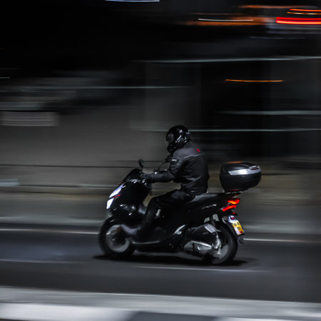 delivery guy driving fast on a motorbikeの写真素材