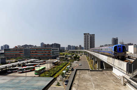Scenic view of a metro train traveling on the elevated rails of Taoyuan Airport MRT System by a bus...