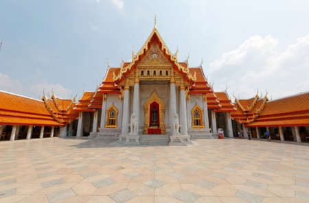 Scenery of Wat Benchamabophit or the famous Marble Temple in Bangkok City, Thailand, a traditional Thai architecture with a decorated gable roof and a courtyard surrounded by corridors under sunny skyのeditorial素材