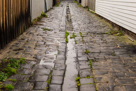 Old, vaguely ominous bluestone back alley, wet with recent rainの写真素材