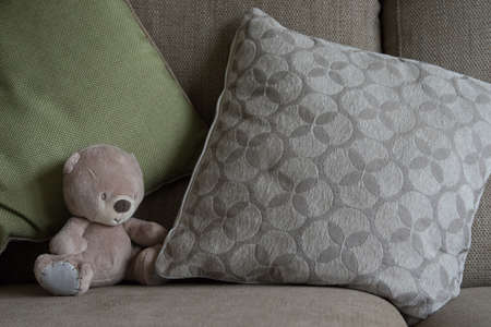 small stuffed bear on a couch, complimentary palette, interior design inspirationの写真素材