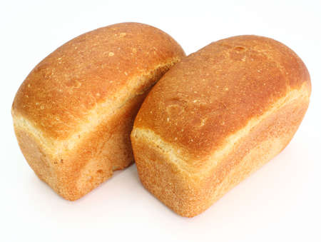 The ruddy long loaf of bread with the fried crust is isolated on a white background