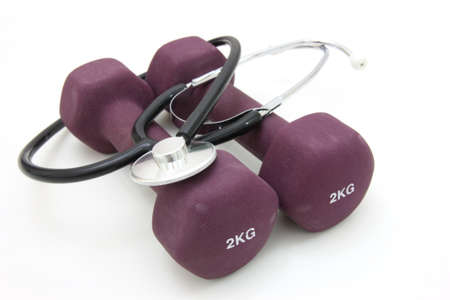 Stethoscope and dumbbell training weights together to conceptualize a healthy lifestyle.の写真素材