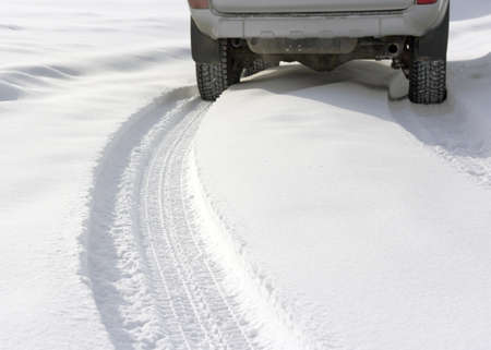 Snowy winter road behind an unrecognizable carの写真素材