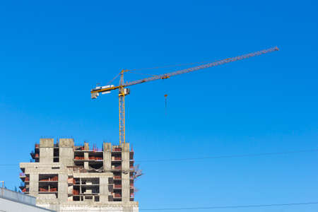 Construction site with two cranes against the sky