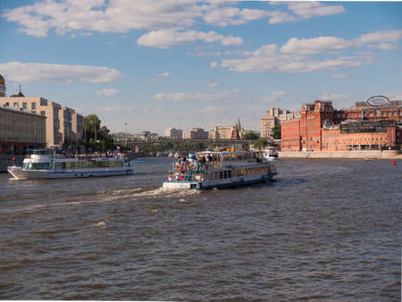 MOSCOW - AUG 25, 2018: Ships sail by Moskva river near bridge summer day.のeditorial素材