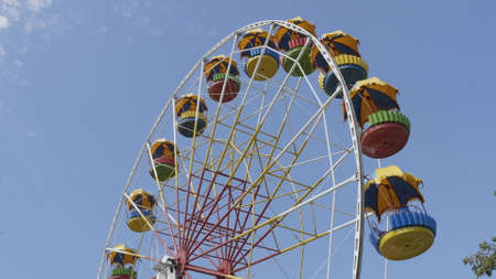 Underside view of a ferris wheel over blue sky.の写真素材
