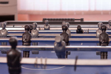 Table football in the entertainment center. Close-up image of plastic players in a football game.