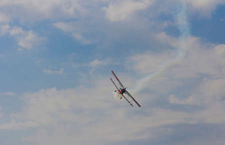 Aircraft AN-2 in a turn against the sky with clouds.