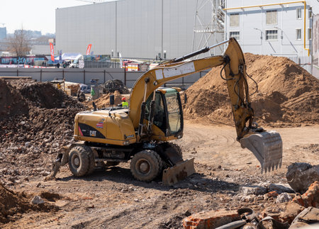 MOSCOW, RUSSIA - MAY 27, 2022: construction excavator of yellow color on the construction site in a quarry for quarrying.のeditorial素材