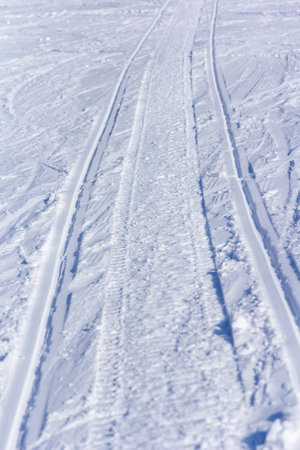 Winter landscape ski track on white snow in frost