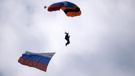 MOSCOW REGION, CHERNOE AIRFIELD 22 May 2021: Skydiver in the sky with a giant flag of Russia against the blue sky.の写真素材