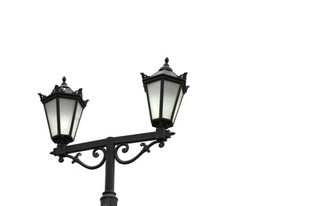 Street light with dual lanterns illuminating the night against a white backdrop.