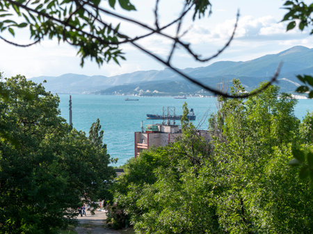 Wild beach on the coast of Kabardinka village, Russia, with cliffs, trees and natural scenery, showcasing coastal landscape and seaside environment.の写真素材