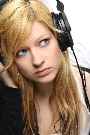 Blonde girl listening music with headphonesの写真素材