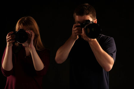 Two photographers on black background