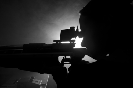 Silhouette of a woman training sport shooting with air rifle gunの写真素材