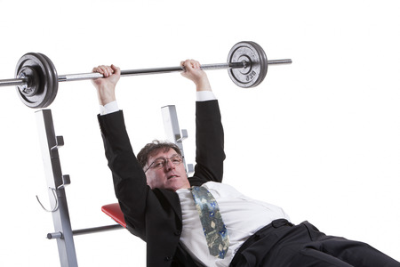 Mature Businessman Lifting Barbell Isolated Over White Backgroundの写真素材