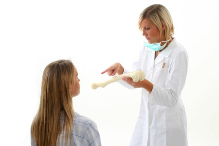 Doctor showing pacient how she has broken her bonesの写真素材