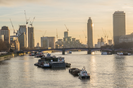 River Thames Boats Against Skyscraper Buildings At Sunset In London, Uk.のeditorial素材