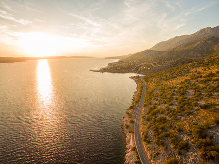 Road along the beautiful sea landscape at sunsetの写真素材