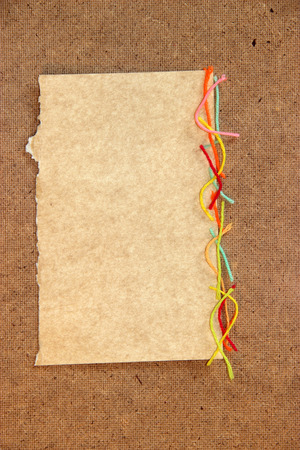 piece of cardboard bright colorful wool thread, piece of paper element laid out on cardboard with a place for accommodation on background for scrapbook, object,の写真素材
