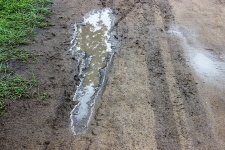 curly dirty puddle tire mark on the country road