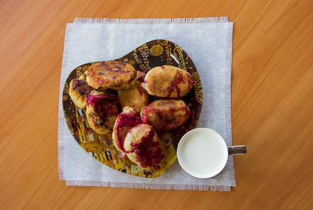 hot pie with berries, fried in oil, lined in a dish, a mug of cold milk, on a napkinの写真素材