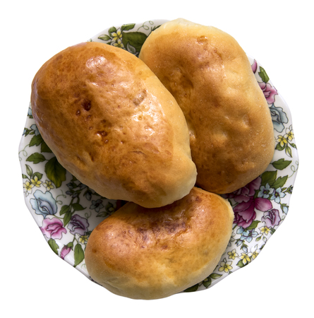 fresh only baked fluffy hot pies with orange crust oiled lie on a thin porcelain saucer isolated on whiteの写真素材