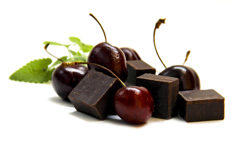 black chocolate lump and dark large cherry isolated on whiteの写真素材