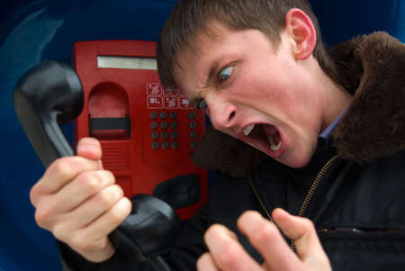 young man talking on the phone with agression outside