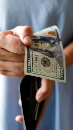 A girl holding one-hundred-dollar bill in her hands